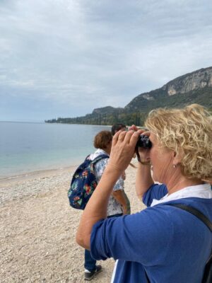 cosa facciamo - socia che osserva con binocolo avifauna sul lago